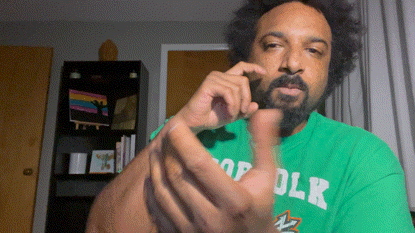 a man with a beard wearing a green shirt with the word olk on it
