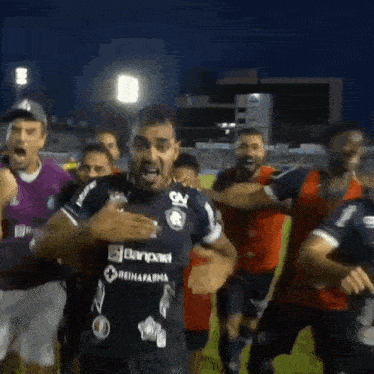 a group of soccer players with one wearing a blue jersey that says reinafarma