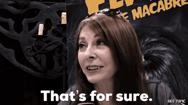 a woman says that 's for sure in front of a sign