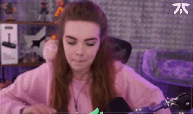 a woman is sitting in front of a microphone making a funny face .