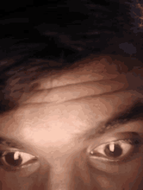 a close up of a man 's eyes with a dark background
