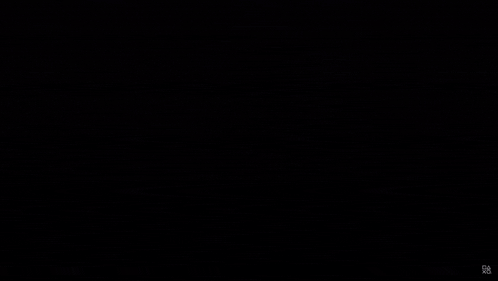 a silhouette of a person standing in front of a wall of monitors with the letters gb on the bottom right