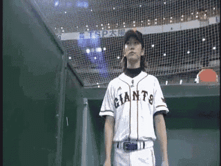 a man in a giants jersey stands in the dugout