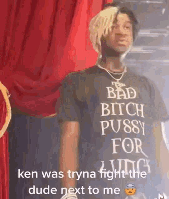 a man wearing a black t-shirt that says `` bad bitch pussy for a king ''