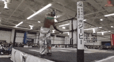 a man in a wrestling ring with a sign in the background that says ' nakamura '