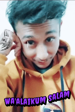 a young man wearing a yellow hoodie with the words wa ' alaikum salam on the bottom