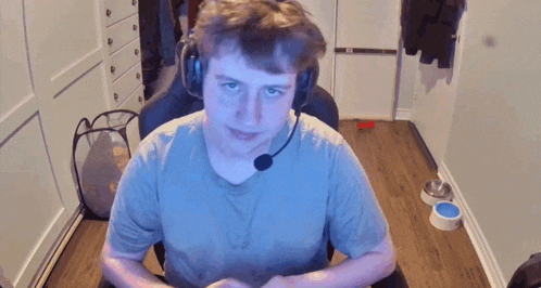 a young man wearing headphones and a microphone is sitting in a chair