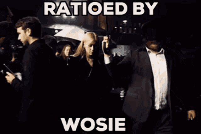 a man in a suit is holding an umbrella next to a woman in a black jacket ..