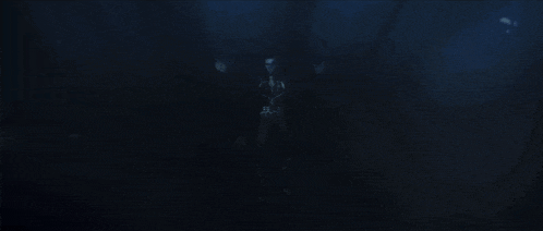 a silhouette of a person in a dark room with a light shining through