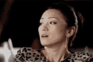 a close up of a woman wearing a leopard print shirt