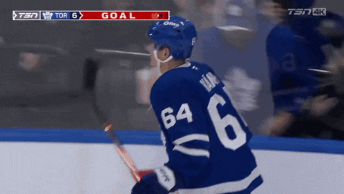a hockey player with the number 64 on his jersey stands on the ice