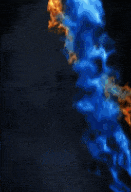 a yellow and blue fire is coming out of a black background .