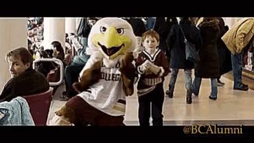 a mascot wearing a college jersey stands in a crowd