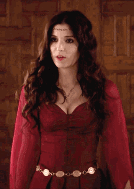 a woman in a red dress with a gold belt