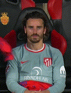 a man wearing a riyadh air jersey sits in a red chair