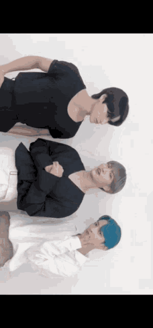 three men are standing next to each other with their arms crossed .