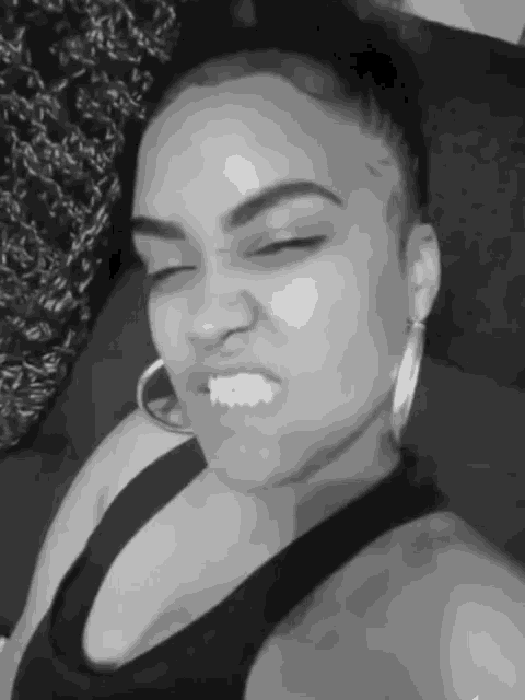 a black and white photo of a woman making a funny face with her eyes closed