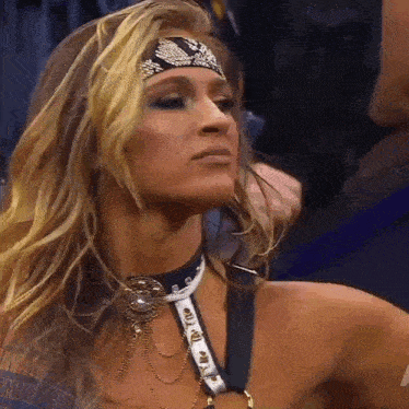 a woman wearing a headband and a choker looks to the side