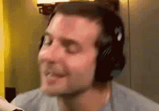 a man wearing headphones is making a funny face while playing a video game .
