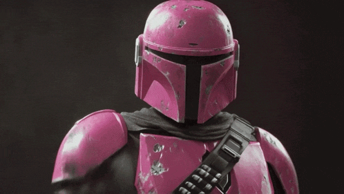 a pink helmet with a black t on the front