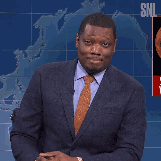 a man in a suit stands in front of a snl sign
