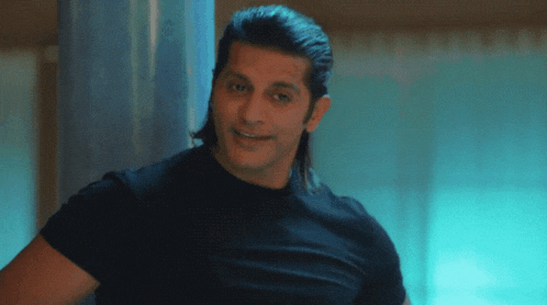 a man with long hair and a black shirt smiles