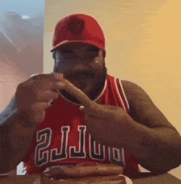 a man wearing a chicago bulls jersey eating a hot dog
