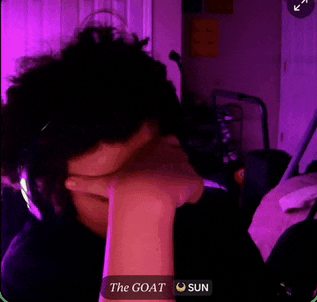 a person is covering their face with their hand in front of a purple background .