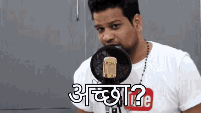 a man wearing a white shirt with a youtube logo on it is speaking into a microphone .
