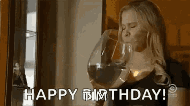 a woman is drinking a glass of wine and says happy birthday .
