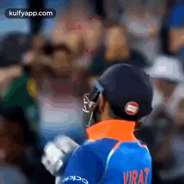 virat is wearing a helmet and a blue shirt