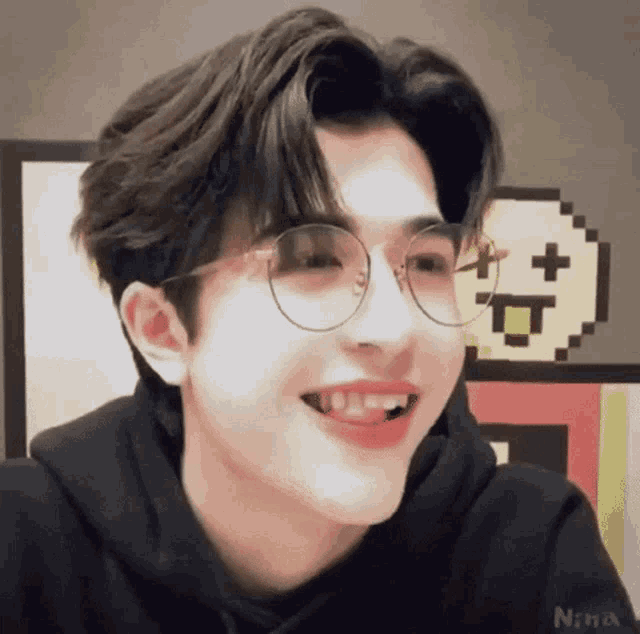 a close up of a person wearing glasses and smiling .