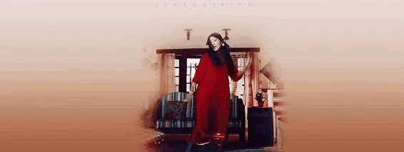 a woman in a red dress is standing in a living room with the word sensitivity on the bottom