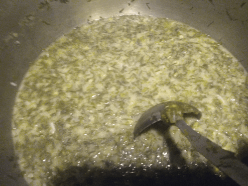 a close up of a pot of soup with a ladle