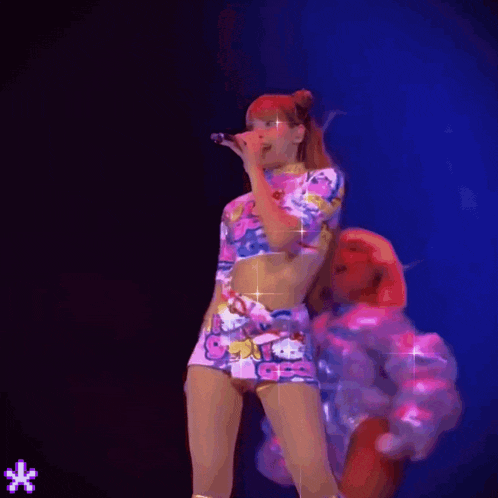 a woman in a hello kitty outfit singing into a microphone