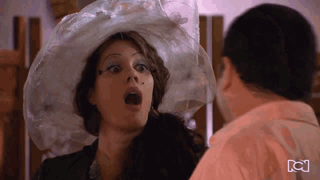 a woman wearing a plastic bag hat stands next to a man
