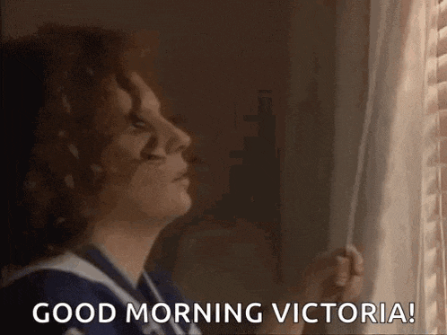 a woman is looking out of a window with the words `` good morning victoria '' written on it .