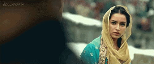 a woman wearing a head scarf is looking at a man .