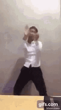 a man in a white shirt and black pants is dancing .