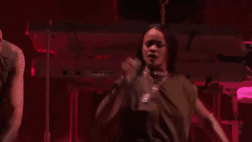 a woman is dancing on a stage in front of a red light .