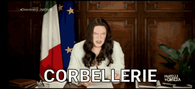 a man with long hair stands in front of a flag and the word corbellerie is on the screen