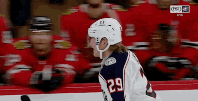 a hockey player with the number 29 on his jersey stands on the ice .