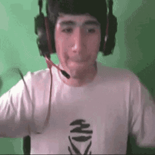 a man wearing headphones and a white shirt with a black x on the front