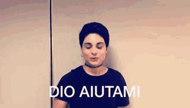 a woman wearing a choker and a black shirt is standing in front of a wall and making a funny face .