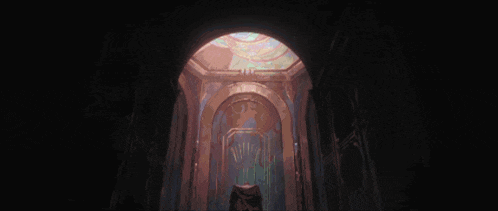 a dark hallway with arches and a statue in the middle of it
