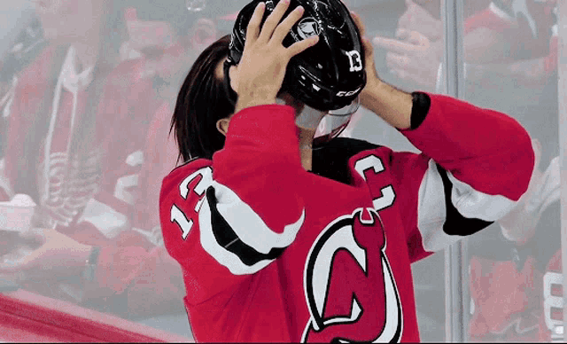 a hockey player wearing a red jersey with the number 12 on it