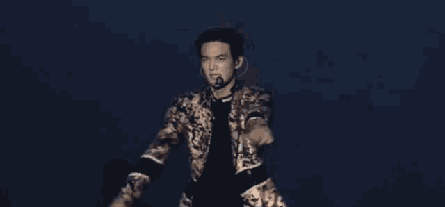 a woman is dancing in a dark room with a microphone in her hand .