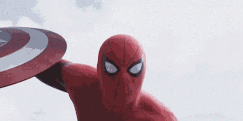 a close up of a spiderman holding a captain america shield in his hand .