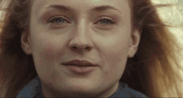 a close up of a woman 's face with blue eyes
