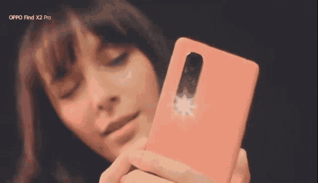 a woman is taking a selfie with an oppo find x2 pro phone